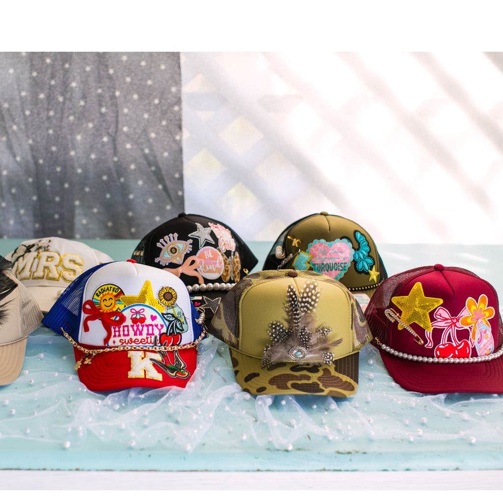 Collection of decorative hats with various designs on a light blue surface.