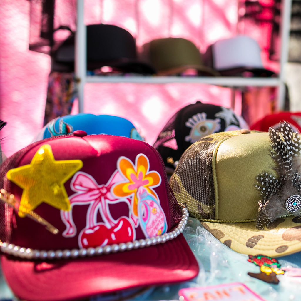 Collection of decorative hats with various designs on a table.
