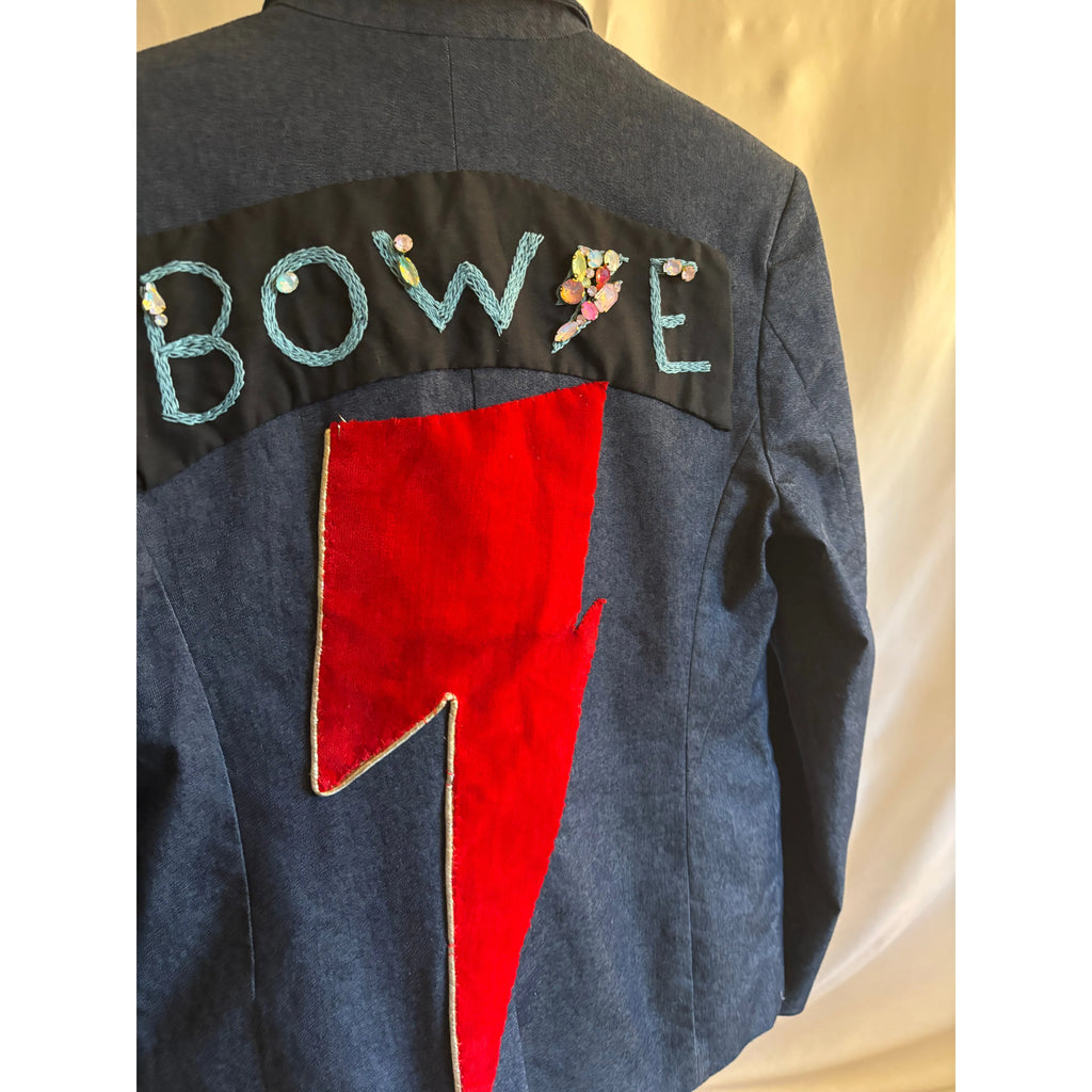 Back of a denim jacket with 'Bowie' embroidered and a red lightning bolt design.