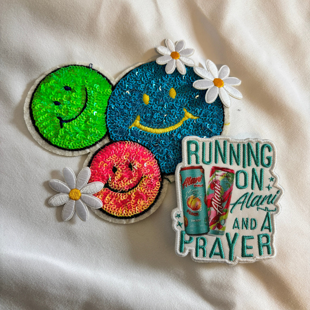 Colorful patch with cartoon designs and text on a white fabric background