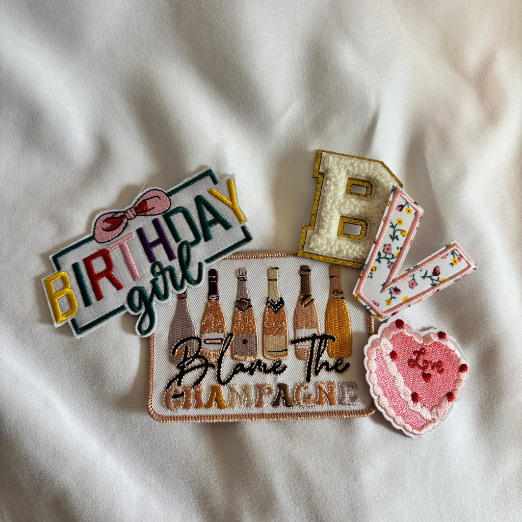 Decorative patches with text and graphics on a white fabric background
