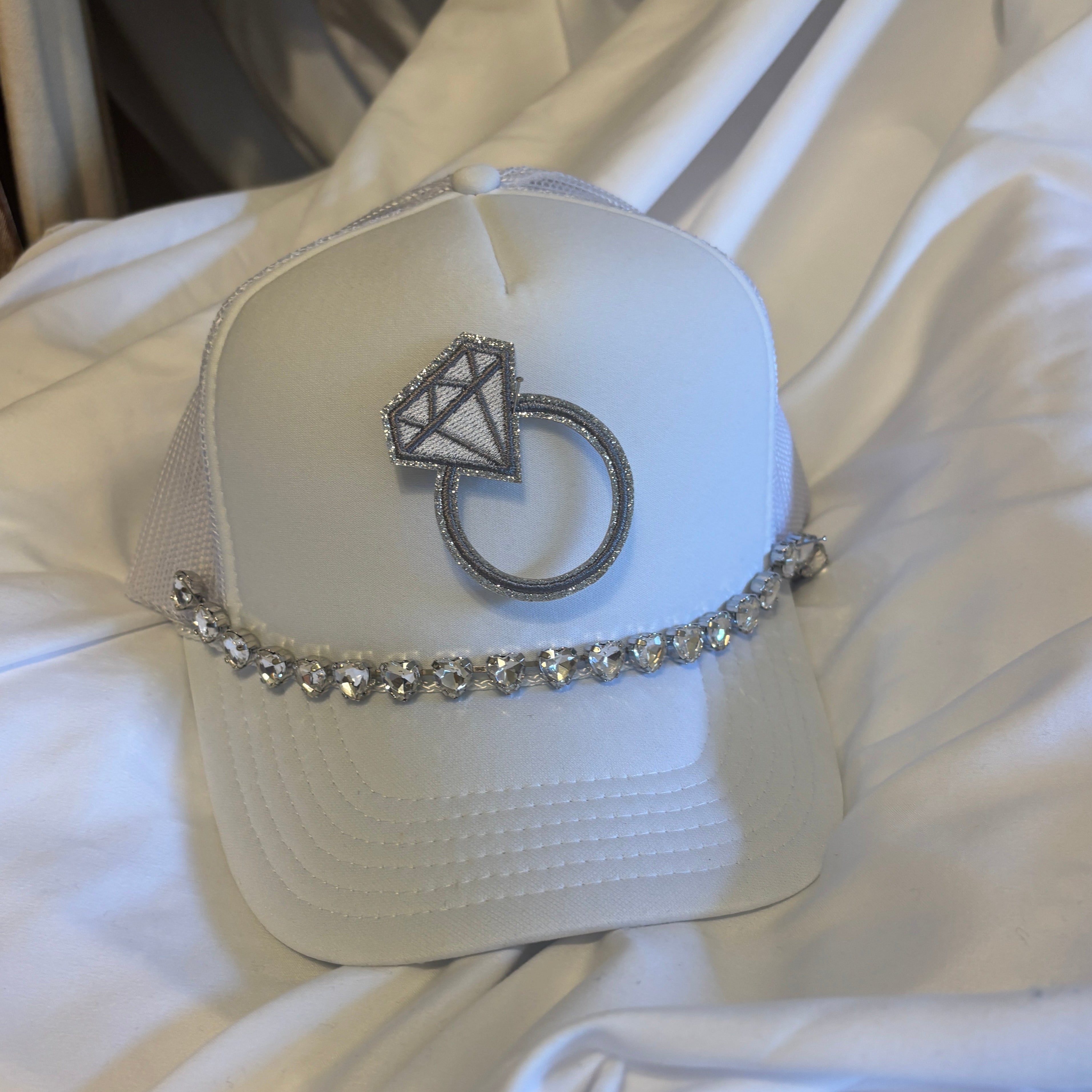 White cap with a decorative ring design on a white background