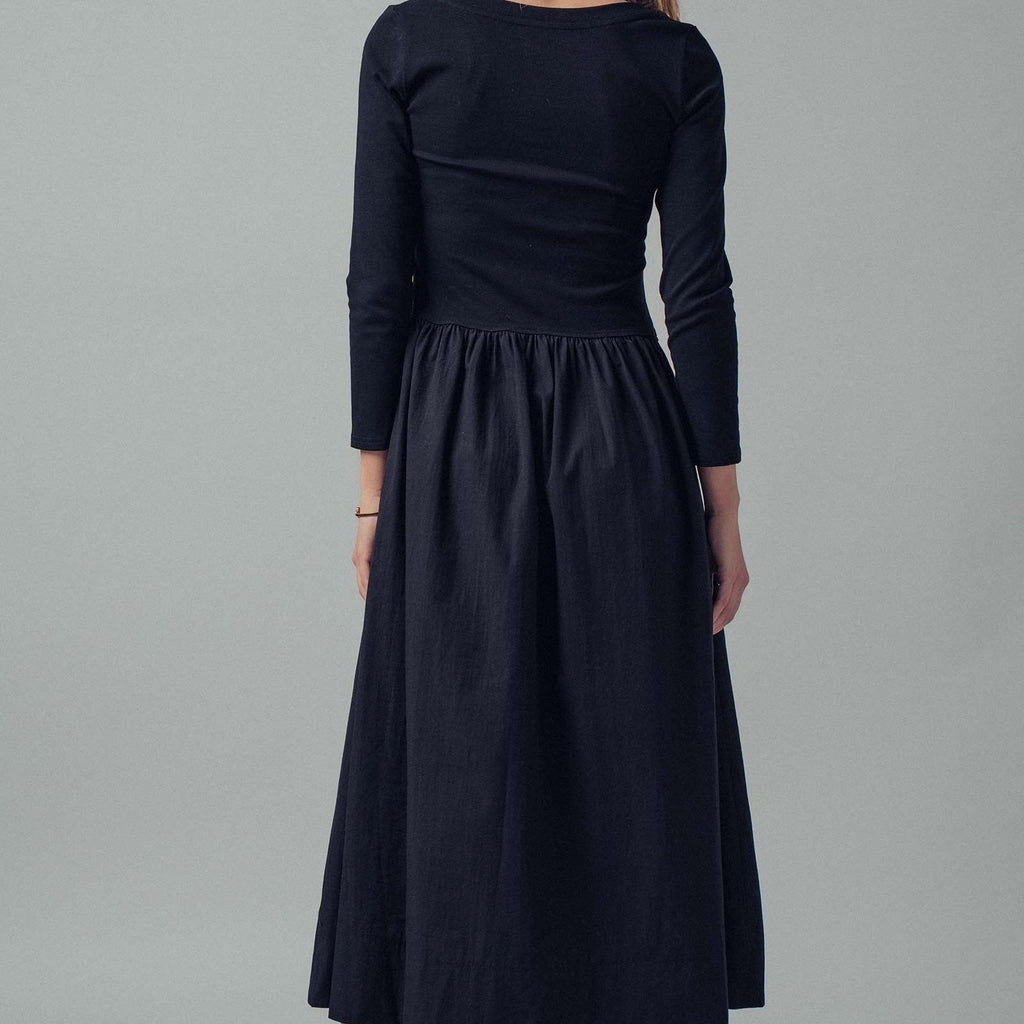 Woman wearing a black dress against a gray background