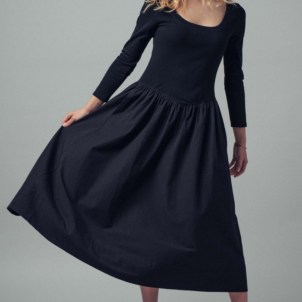Woman wearing a black dress against a gray background