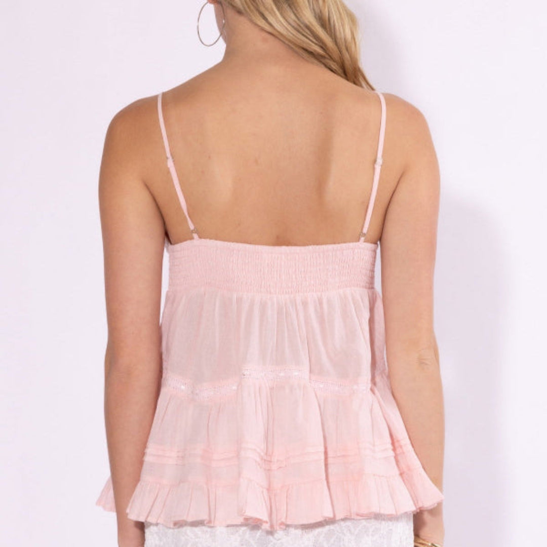 Woman wearing a pink layered top against a white background